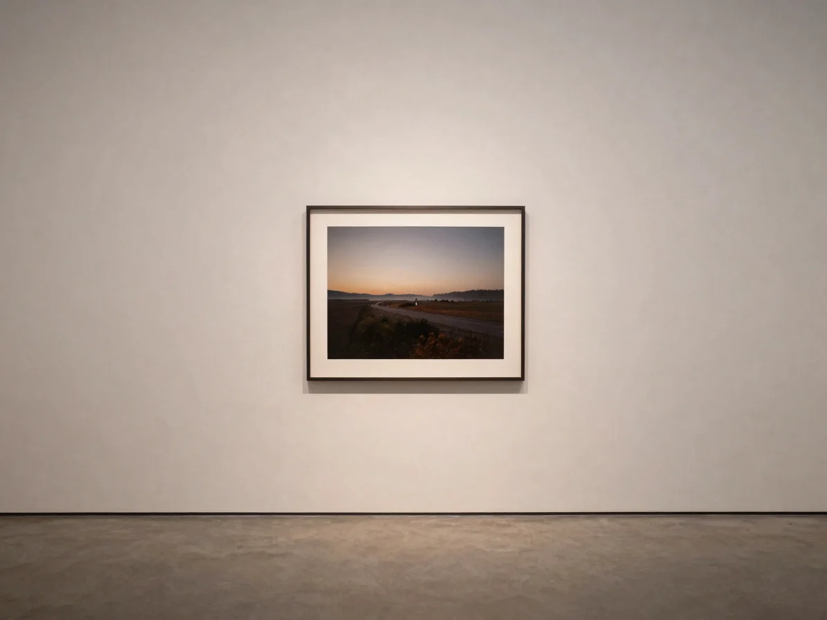 Editorial gallery photography, soft diffused gallery light, neutral tonal palette, a single framed artwork on a pale wal